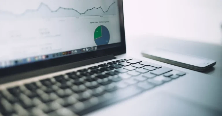 Ekran laptopa z pulpitem danych na biurku w firmie handlowej